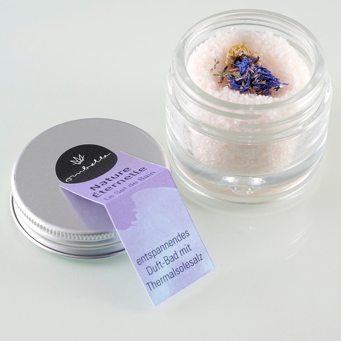 Ombelle Badesalz Nature Éternelle 30g im Glastiegel mit geöffnetem Deckel. in das Salz eingebettet, findest du eine echte Kornblume.