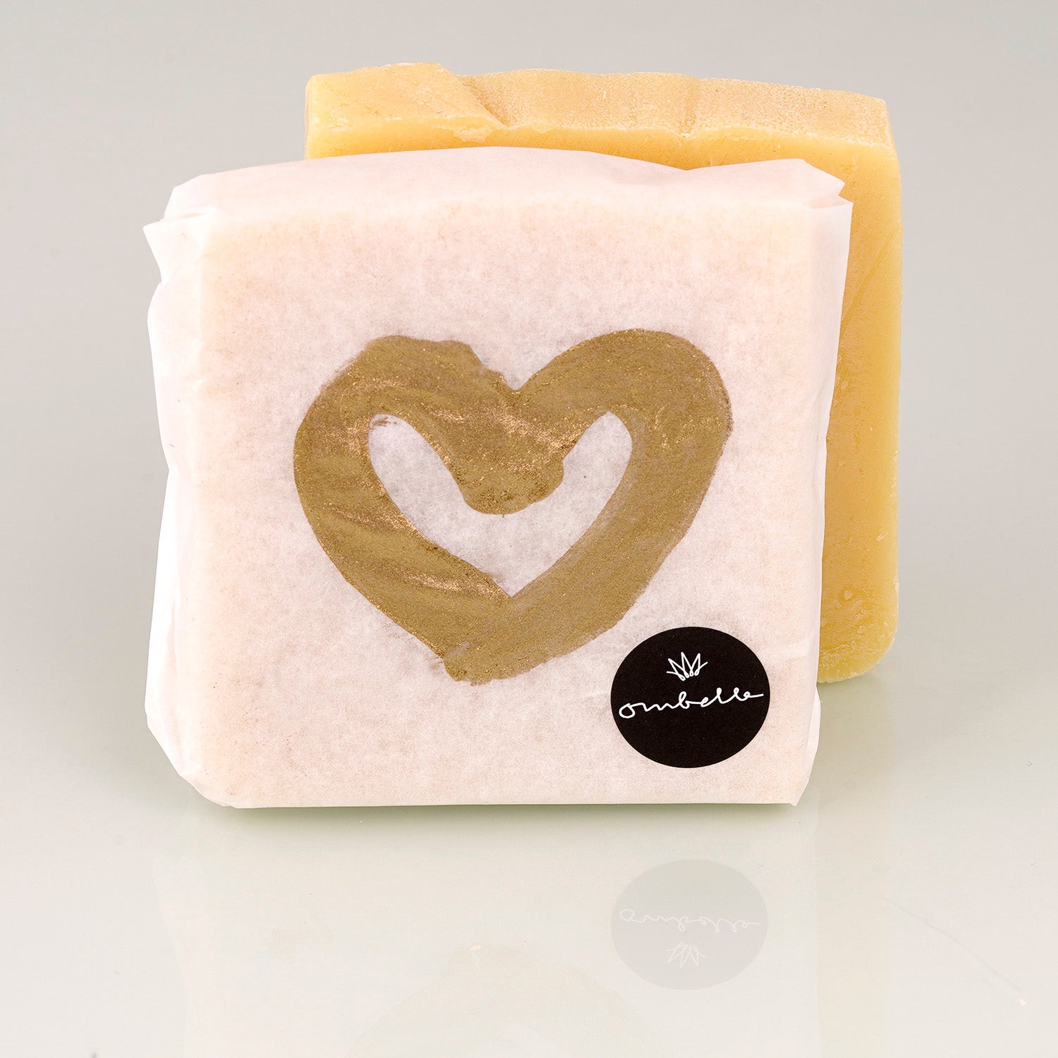 Ombelle Naturseife La Parisienne mit Bio-Sheabutter, kaltgesiedet mit Goldherz, Limitiert, Bild der Seife uneingepackt im Hintergrund.
